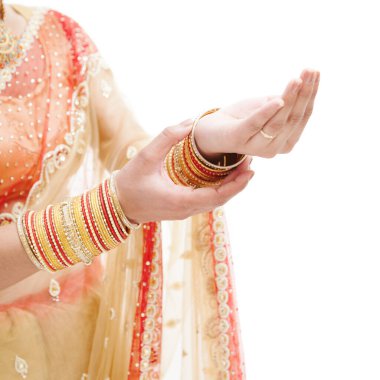 Düğün sırasında geleneksel altın bilezikler takan Hintli bir gelinin güzel elleri.