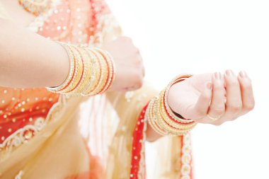 Düğün sırasında geleneksel altın bilezikler takan Hintli bir gelinin güzel elleri.