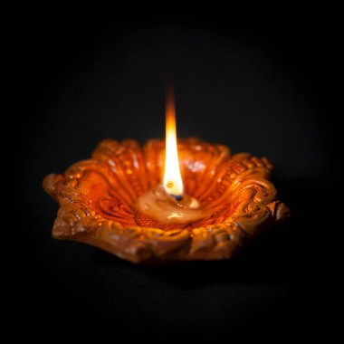 El yapımı güzel bir tasarımcı, arka planda renkli ışıklara karşı yanan fitili olan Clay Lambası.. 