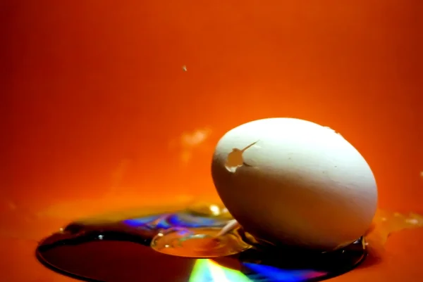 Zerbrochenes Ei mit seinem Inhalt, der nach einem Schuss auf ein c ausgeschüttet wurde — Stockfoto