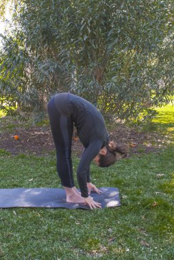 Güneşli bir günde pratik Yoga parkta güzel kadın