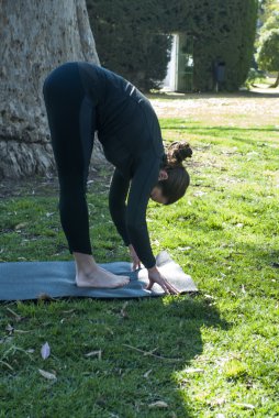 Güneşli bir günde pratik Yoga parkta güzel kadın