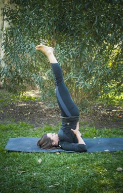 Güneşli bir günde pratik Yoga parkta güzel kadın