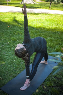 Güneşli bir günde pratik Yoga parkta güzel kadın