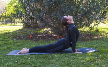 Güneşli bir günde pratik Yoga parkta güzel kadın