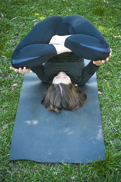 Mooie vrouw beoefenen van yoga in het park op een zonnige dag — Stockfoto