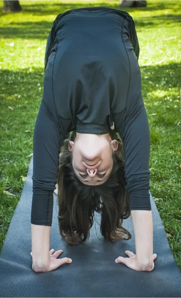 Mooie vrouw beoefenen van yoga in het park op een zonnige dag — Stockfoto