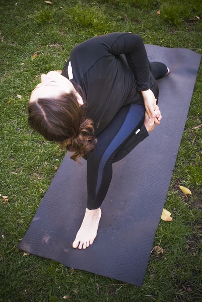 Mulher bonita praticando ioga no parque em um dia ensolarado — Fotografia de Stock