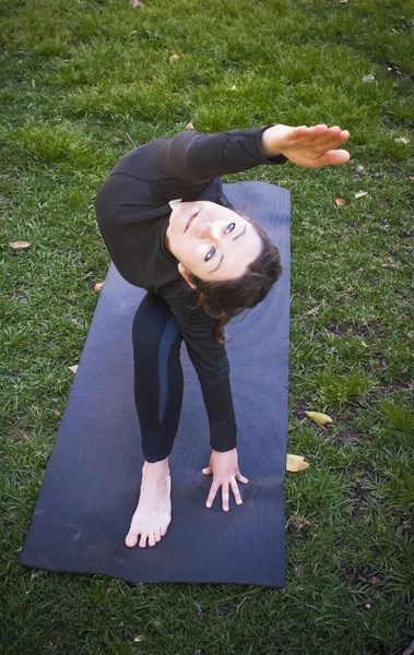 Mooie vrouw beoefenen van yoga in het park op een zonnige dag — Stockfoto