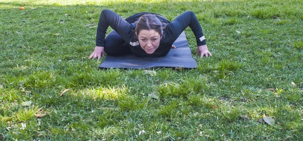 Mulher bonita praticando ioga no parque em um dia ensolarado — Fotografia de Stock