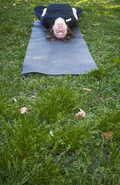 Güneşli bir günde pratik Yoga parkta güzel kadın