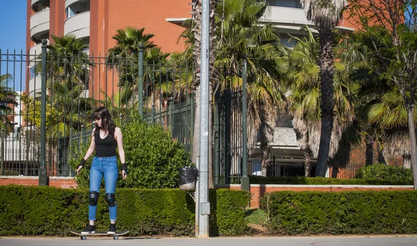 Vacker ung kvinna tränar med skateboard på stre — Stockfoto