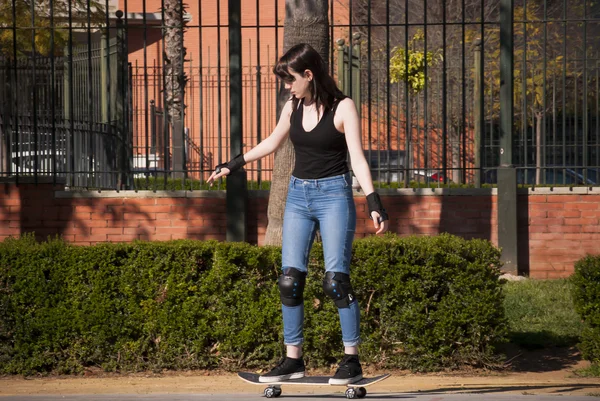 Красивая молодая женщина практикуется со скейтбордом на улице — стоковое фото