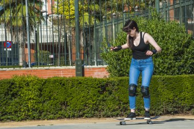 Güzel genç kadın sokakta kaykay ile pratik