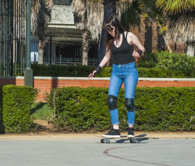 Güzel genç kadın sokakta kaykay ile pratik