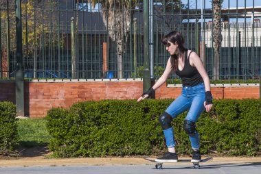 Güzel genç kadın sokakta kaykay ile pratik