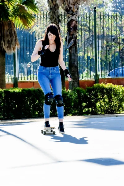 Mooie jonge vrouw, oefenen met de skateboard op de straat — Stockfoto