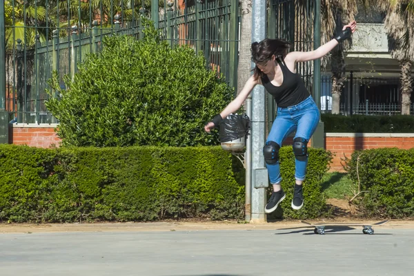 Bella giovane donna che pratica con lo skateboard per strada — Foto Stock
