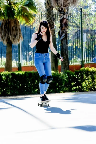 Mooie jonge vrouw, oefenen met de skateboard op de straat — Stockfoto