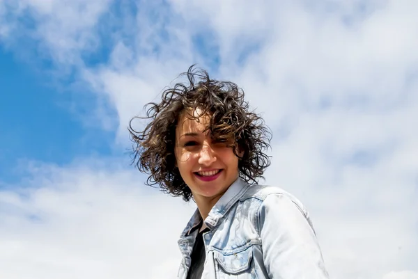 Mulher bonita com um céu com nuvens de fundo — Fotografia de Stock