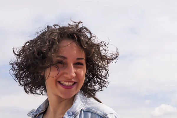 Mulher bonita com um céu com nuvens de fundo — Fotografia de Stock