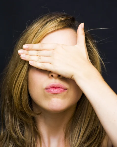 Portret van een mooie vrouw die betrekking hebben op haar ogen met haar handen — Stockfoto