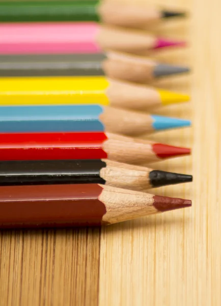 Colored pencils on a wooden background — Stock Photo, Image