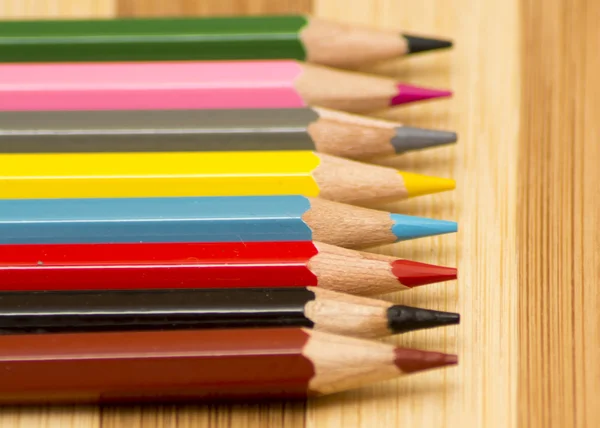 Colored pencils on a wooden background — Stock Photo, Image