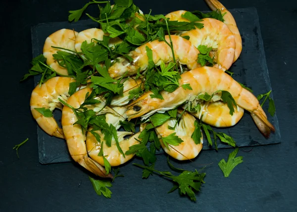 Camarones con perejil sobre pizarra de piedra — Foto de Stock