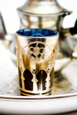 Çaydanlık grubu ve beyaz arka planda bir tepside bir bardak oryantal çay.