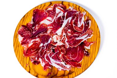 Beyaz arka planda ahşap tepside jambon parçaları.