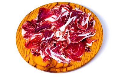 Beyaz arka planda ahşap tepside jambon parçaları.