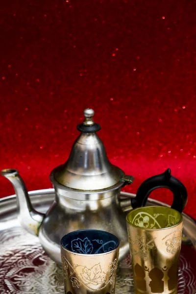 ティーポットと東洋茶のグラスをトレイの上に赤い背景にキラキラと — ストック写真