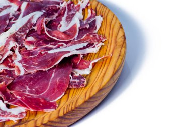 Beyaz arka plandaki ahşap tepside tipik İspanyol jambonu.