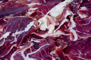 Beyaz arka plandaki ahşap tepside tipik İspanyol jambonu.