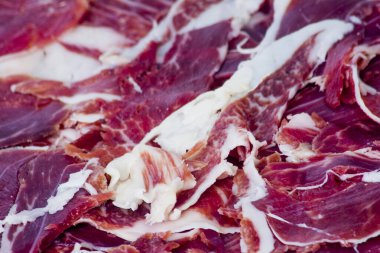 Beyaz arka plandaki ahşap tepside tipik İspanyol jambonu.