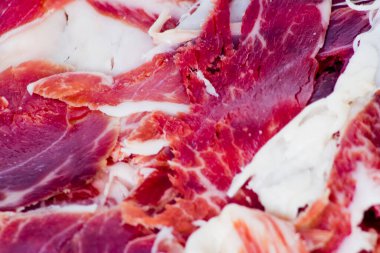 Beyaz arka plandaki ahşap tepside tipik İspanyol jambonu.