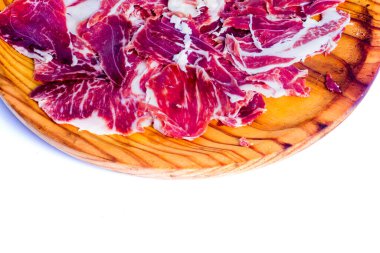 Beyaz arka plandaki ahşap tepside tipik İspanyol jambonu.