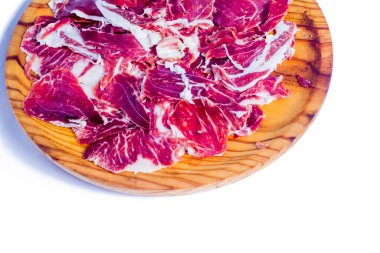 Beyaz arka plandaki ahşap tepside tipik İspanyol jambonu.