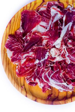 Beyaz arka plandaki ahşap tepside tipik İspanyol jambonu.