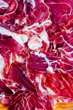 Beyaz arka plandaki ahşap tepside tipik İspanyol jambonu.