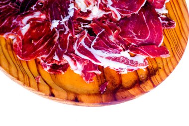 Beyaz arka plandaki ahşap tepside tipik İspanyol jambonu.