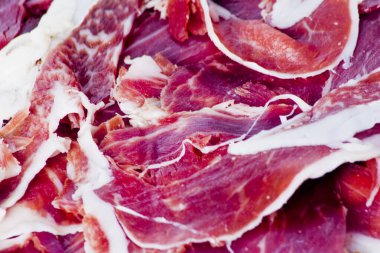 Beyaz arka plandaki ahşap tepside tipik İspanyol jambonu.