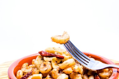 Tahta tepside seramik kasede sarımsak ve kırmızı biberli lezzetli karidesler.