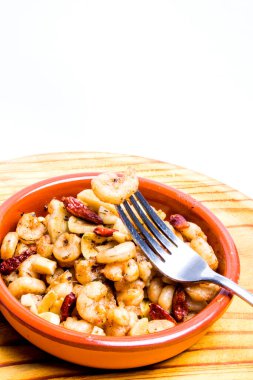 Tahta tepside seramik kasede sarımsak ve kırmızı biberli lezzetli karidesler.