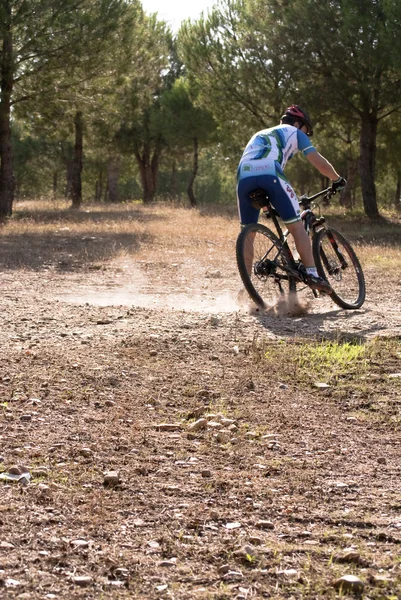 Ciclista en carreras de bicicleta de montaña haciendo una carrera en el campo — Foto de Stock