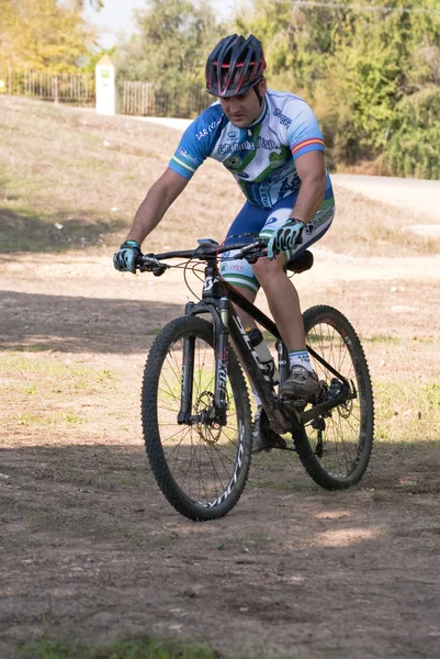 Ciclista en carreras de bicicleta de montaña haciendo una carrera en el campo — Foto de Stock