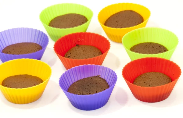 Chocolate muffins in silicone holders of many colors — Stock Photo, Image