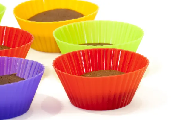 Chocolate muffins in silicone holders of many colors — Stock Photo, Image