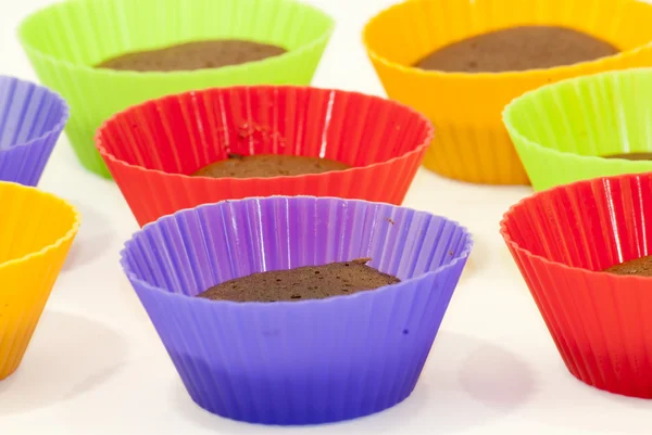 Chocolate muffins in silicone holders of many colors — Stock Photo, Image